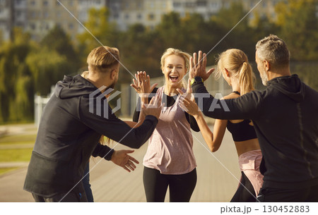 Happy Group Of People Working Out Together In A City Park And Giving High Fives 130452883