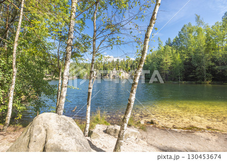 The Piskovna lake in Adrspach-Teplice Rocks area, in Hradec Kralove Region in Czech Republic, Europe. Scenic lake view framed by birch trees and lush greenery, capturing a tranquil summer landscape. 130453674