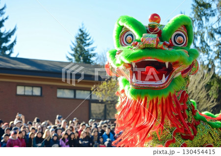 Green Chinese dragon head with red mane performing on lunar new year in front of a crowd 130454415