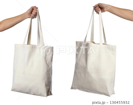 Canvas tote bag held in hand by its straps, casual eco-friendly shopping bag isolated on transparent background 130455932