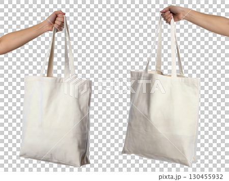 Canvas tote bag held in hand by its straps, casual eco-friendly shopping bag isolated on transparent background 130455932