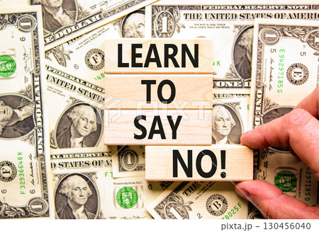 Learn to say no symbol. Concept words phrase Learn to say no on beautiful wooden blocks. Dollar bills. Beautiful dollar bills background. Business psychological Learn to say no concept. Copy space. 130456040