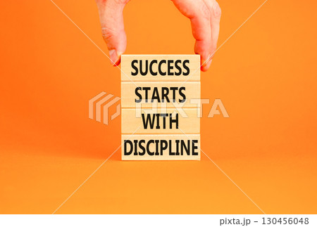 Success starts with discipline symbol. Concept words Success starts with discipline on beautiful wooden blocks. Beautiful orange background. Business success starts with discipline concept. Copy space 130456048