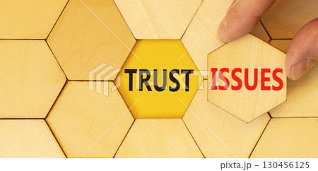 Trust issues symbol. Concept word Trust issues on beautiful wooden puzzles. Businessman's hand. Beautiful yellow paper background. Business trust issues concept. Copy space. Trust issues symbol. Concept word Trust issues on beautiful wooden puzzles. Businessman's hand. Beautiful yellow paper background. Business trust issues concept. Copy space. 130456125