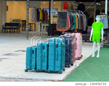 Line of suitcases standing on the pavement. Travel preparation, luggage and vacation journey. 130456710