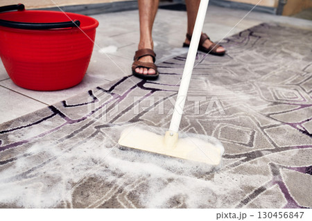 Man scrubbing rug with brush and soap outdoors Man scrubbing rug with brush and soap outdoors 130456847