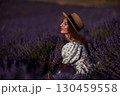 Lavender Woman Summer: Lady in lavender field enjoys sun with bouquet during summer. 130459558