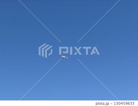 Airplane flying in clear blue sky at high altitude with visible red tailfin. Aviation, transportation, speed, and global connectivity through air travel. Airplane flying in clear blue sky at high altitude with visible red tailfin. Aviation, transportation, speed, and global connectivity through air travel. 130459635
