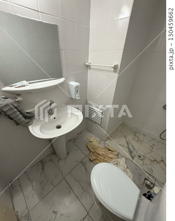 Small bathroom interior with sink, toilet and mirror in bright light. Hygiene, facility, daily usage and essential element of accommodation and personal care environment. Small bathroom interior with sink, toilet and mirror in bright light. Hygiene, facility, daily usage and essential element of accommodation and personal care environment. 130459662