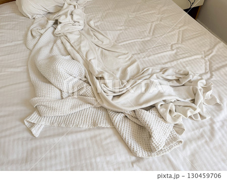 Closeup of white blanket and sheet with folds and creases on bed. Textile, comfort, domestic lifestyle, hospitality and accommodation environment detail. Closeup of white blanket and sheet with folds and creases on bed. Textile, comfort, domestic lifestyle, hospitality and accommodation environment detail. 130459706