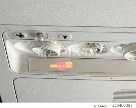 Closeup of airplane cabin panel with air vents and light controls. Passenger service and aviation engineering. 130460385