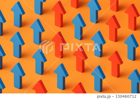 Bright orange surface features blue and red arrows arranged in geometric rows, symbolizing business growth and direction 130460712
