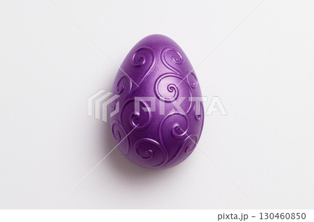 Metallic purple Easter egg with ornate swirls on white background, perfect for seasonal decoration and minimalist holiday themes 130460850