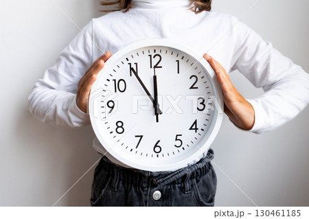 Caucasian child holding large wall clock 130461185