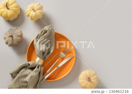 Autumn composition of colorful small pumpkins, empty plate with cutlery. 130461216