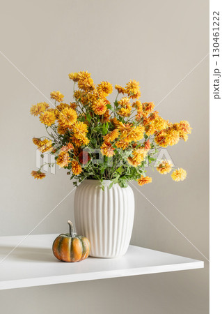 Autumn yellow and orange flowers in white vase and pumpkin 130461222
