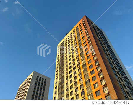 A high-rise apartment building on a blue sky background. New building. High quality photo A high-rise apartment building on a blue sky background. New building. High quality photo 130461417