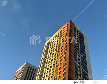 A high-rise apartment building on a blue sky background. New building. High quality photo A high-rise apartment building on a blue sky background. New building. High quality photo 130461430
