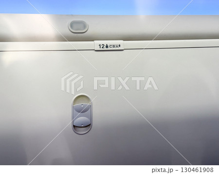 Closed overhead locker inside airplane cabin with seat number label visible. Aviation storage, travel organization and air transport interior design element. Closed overhead locker inside airplane cabin with seat number label visible. Aviation storage, travel organization and air transport interior design element. 130461908