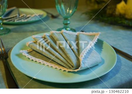 Festive table setting with a napkin on a plate Festive table setting with a napkin on a plate 130462210
