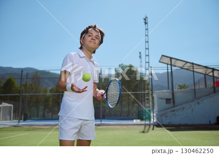 Young Tennis Player on Outdoor Court with Racquet and Ball Under Sunny Sky Young Tennis Player on Outdoor Court with Racquet and Ball Under Sunny Sky 130462250