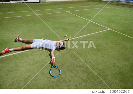 Tennis Player Sprawled on Court After Intense Match on Grass Surface 130462267
