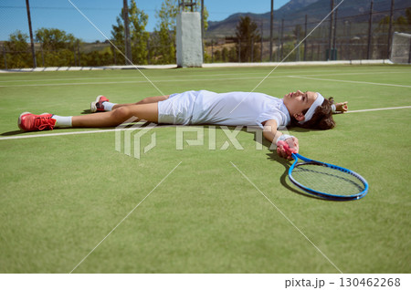 Young Tennis Player Lying Exhausted on the Court After Intense Match Young Tennis Player Lying Exhausted on the Court After Intense Match 130462268