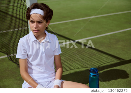Young Athlete Sitting on Tennis Court After Session Under Sunlight 130462273