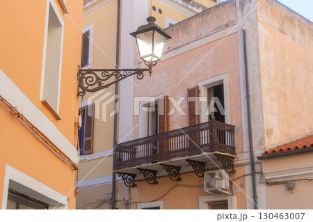 Mediterranean-style building facade featuring a decorative wrought iron balcony and vintage street lamp. The pastel tones and architectural details create a quaint, timeless atmosphere Mediterranean-style building facade featuring a decorative wrought iron balcony and vintage street lamp. The pastel tones and architectural details create a quaint, timeless atmosphere 130463007
