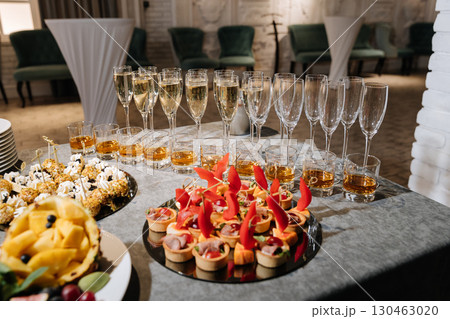 Elegant catering with sparkling wine and appetizers at a formal indoor event Elegant catering with sparkling wine and appetizers at a formal indoor event 130463020