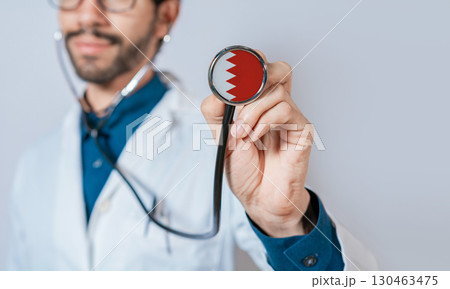 Doctor holding stethoscope with Bahrain flag. Bahrain health and care concept, Bahrain flag on stethoscope 130463475