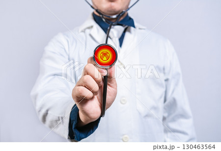 Doctor hands holding stethoscope with Kyrgyzstan flag. Kyrgyzstan health and care concept 130463564