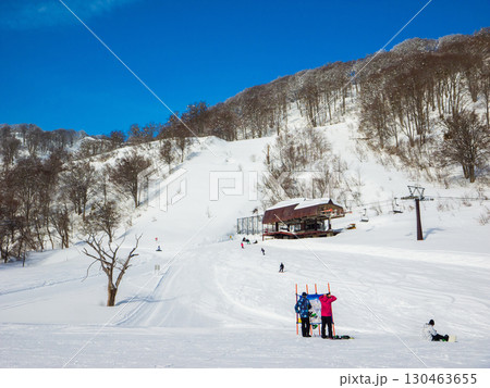 快晴のスキー場頂上でゲレンデマップを確認するスノーボーダー達 (長野県、飯山市、戸狩温泉) 130463655