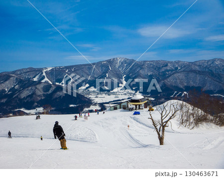 戸狩温泉スキー場の頂上から望むゲレンデと雪を纏った山脈 (長野県, 飯山市) 130463671