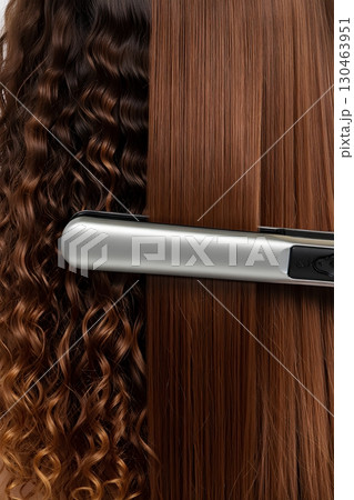 Beauty shot of ceramic flat iron smoothing frizzy hair, salon-grade styling tool 130463951