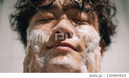洗顔中の男性 アップ写真 浴室で泡立つ顔とリラックスした表情 朝のスキンケア風景 130464919