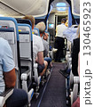 Interior view of an airplane cabin showing passengers seated, with flight attendants preparing for service, creating a sense of travel and adventure in the air 130465923