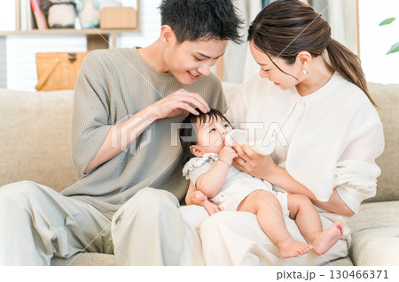 マイホームのソファーで赤ちゃんに哺乳瓶でミルクをあげるママとパパ(育休,育児休暇) マイホームのソファーで赤ちゃんに哺乳瓶でミルクをあげるママとパパ(育休,育児休暇) 130466371
