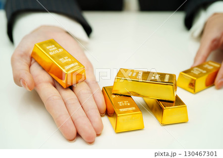 Asian woman holding gold bar in finance business. 130467301