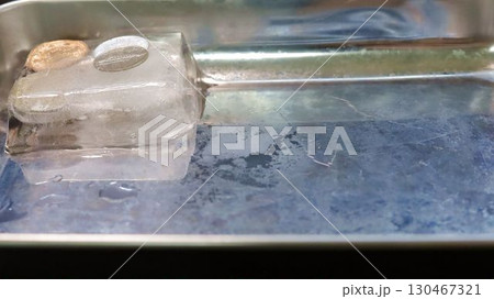 氷に閉じ込められ津貨幣が溶け出す。開放、解禁のイメージ 130467321