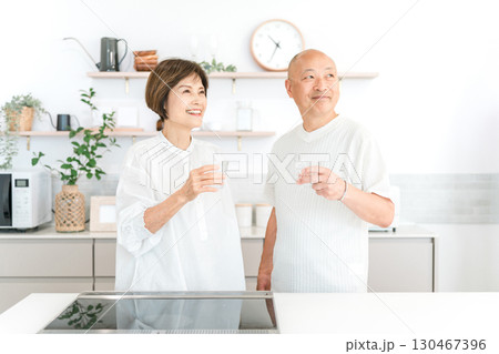 マイホームのキッチンで水を飲む中高年の夫婦,カップル マイホームのキッチンで水を飲む中高年の夫婦,カップル 130467396