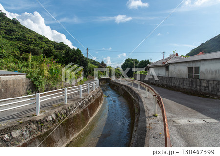 快晴の田舎の路地裏の両側に細い道がある細く小さい川 130467399