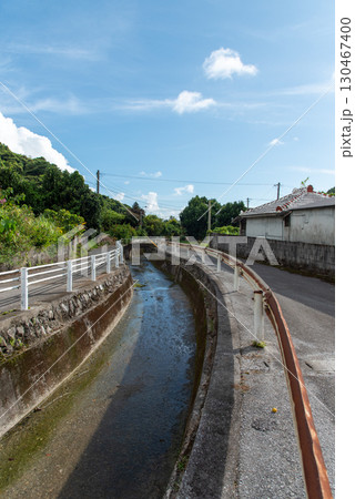 快晴の田舎の路地裏の両側に細い道がある細く小さい川 130467400