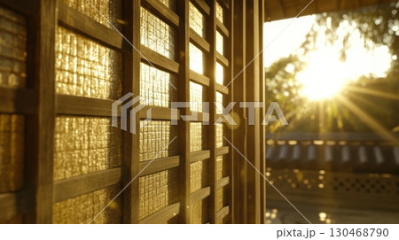 Sunlight streaming through wooden lattice with warm glow at sunset in a serene location 130468790