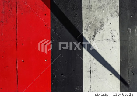 Bold geometric pattern features red, black, and white stripes under natural light with shadow play 130469325