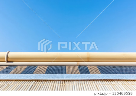 Traditional bamboo structure contrasting with a clear blue sky during midday in a tranquil outdoor setting 130469559