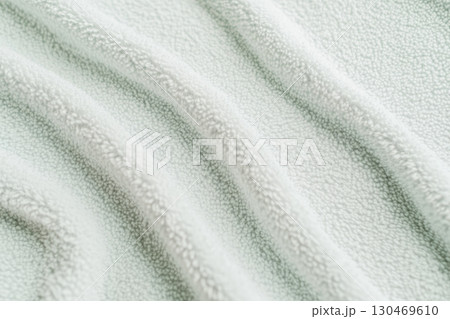 Soft textured fabric lays in gentle waves creating a visually soothing pattern in neutral tones 130469610
