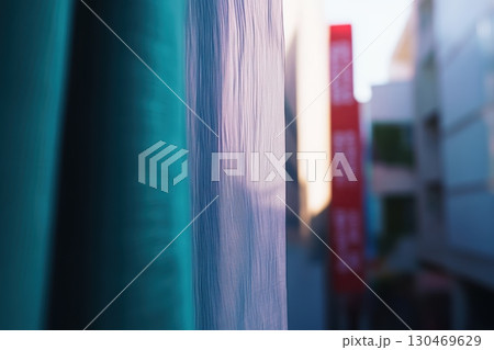 Softly draping curtain filters sunlight over a busy street in the late afternoon 130469629