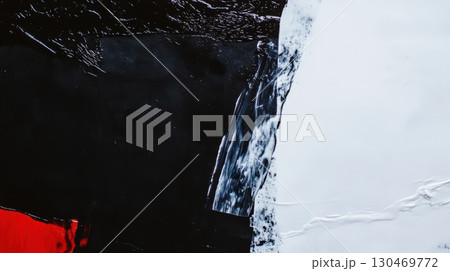 Abstract art composition featuring black, white, and red colors with textured paint layers 130469772