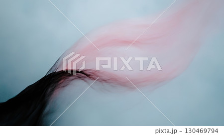 Colorful wisps of hair flowing gracefully against a soft backdrop in a creative artistic setting 130469794